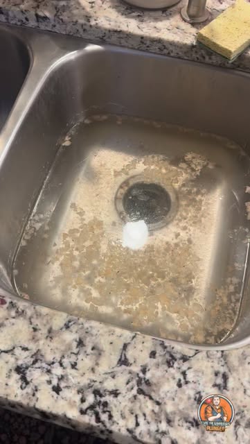 Clearing a clogged kitchen sink drain by removing the pipes